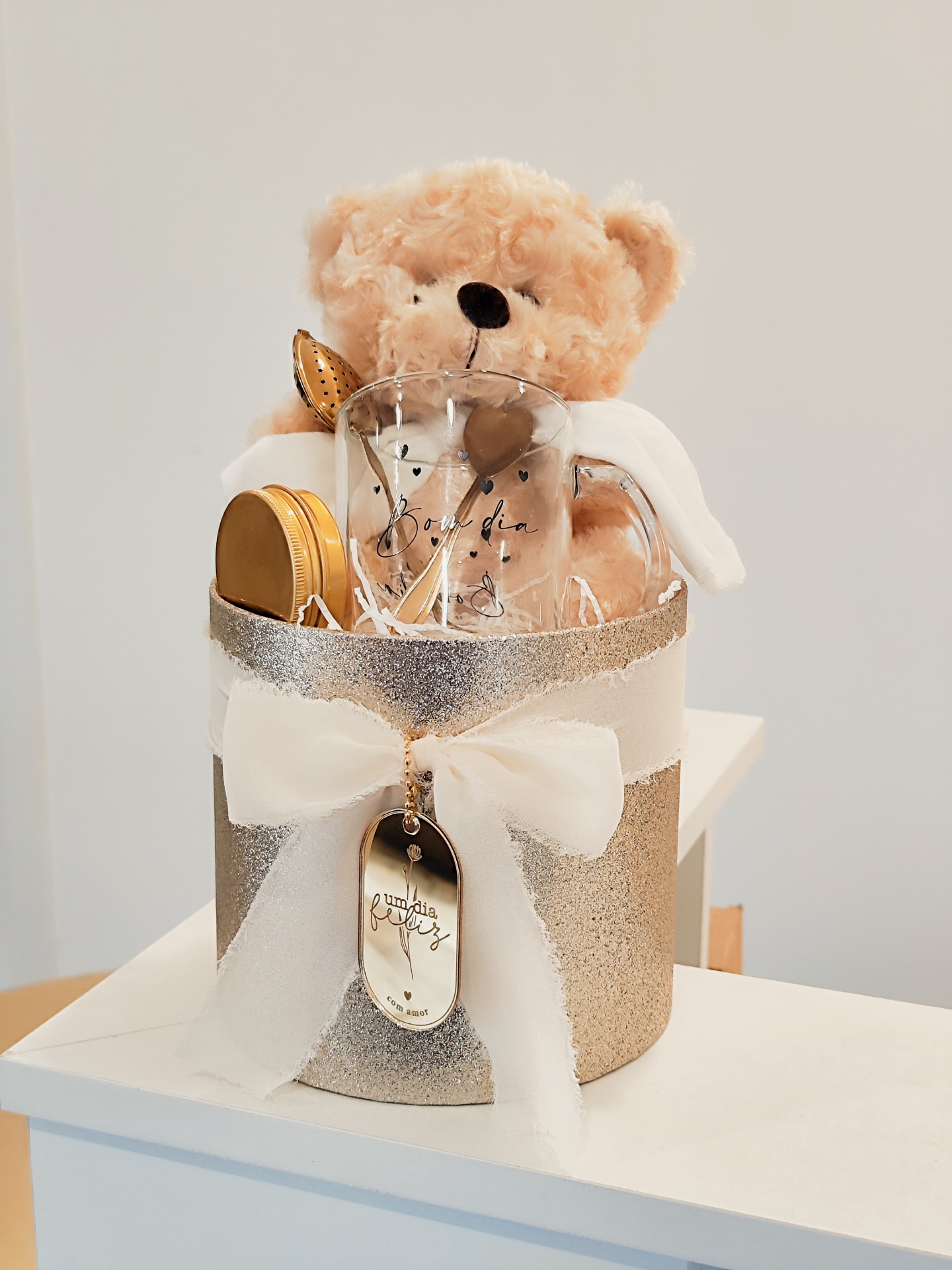 Conjunto de presente com ursinho de peluche, caneca e colher em caixa brilhante dourada com fita branca