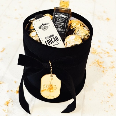 Caixa preta com mini garrafa de Jack Daniels, chocolates dourados e chaveiro branco