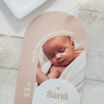 Convite em papel texturizado com foto de bebé e texto em português.
