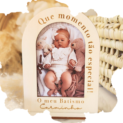 Moldura de madeira com foto de bebé e texto gravado, ao lado de cesta de verga