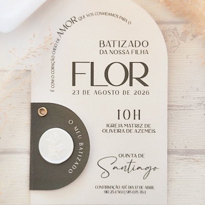 Convite de batizado da filha Flor, papel bege texturizado com detalhe em couro castanho escuro e selo branco, texto em preto.