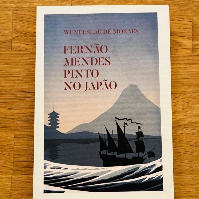 Livro FERNÃO MENDES PINTO NO JAPÃO com ilustração de barco, ondas e montanha