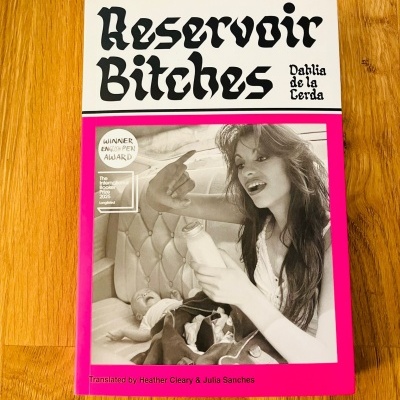 Capa do livro Reservoir Bitches com fotografia a preto e branco de mulher a alimentar bebé