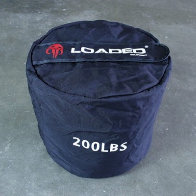 Saco de peso preto com inscrições Loaded e 200LBS sobre chão cinzento