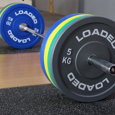 Pesos LOADED de 5 KG em barra de levantamento com discos coloridos num ginásio