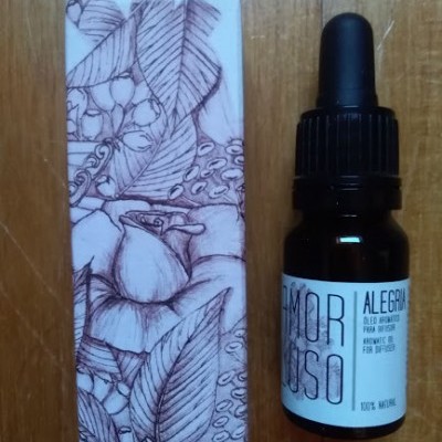 Frasco com conta-gotas óleo aromático ao lado de caixa com desenho de folhas