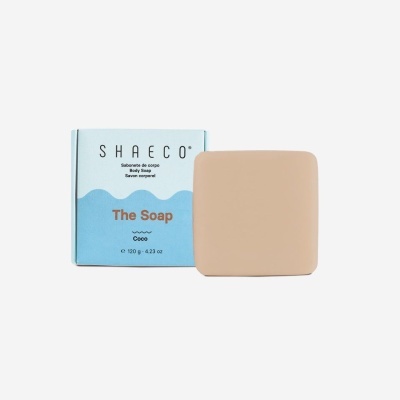 Sabonete cuadrado beige junto a caja azul claro y blanca con texto de marca SHAECÓ y descripción del producto.