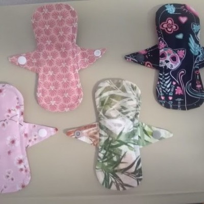 Quatro pensos reutilizáveis coloridos com diferentes padrões florais e decorativos