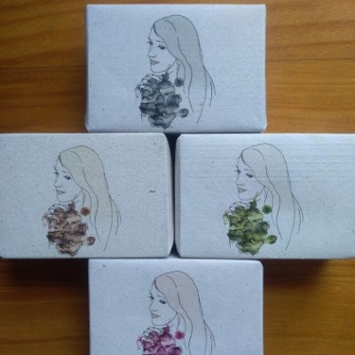 Quatro caixas brancas com ilustrações de mulher e flores em cores variadas