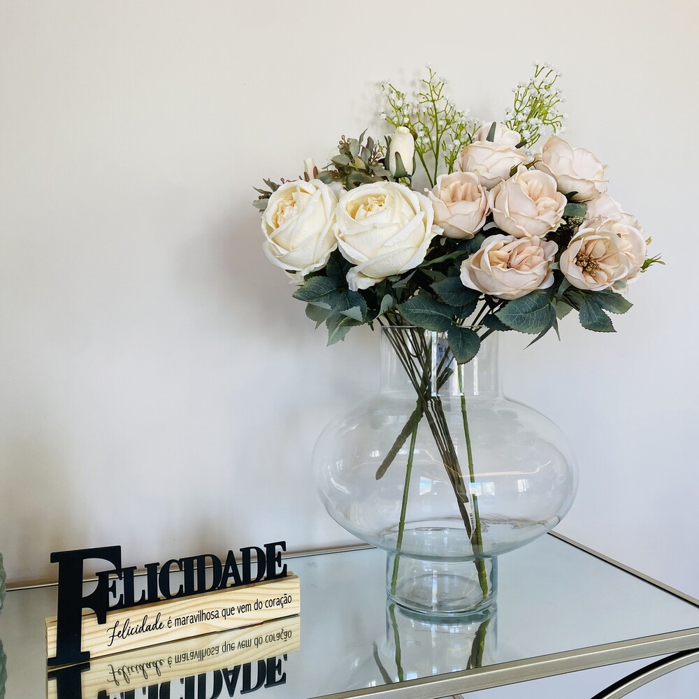 vaso de vidro com flores artificiais e placa decorativa com texto em português