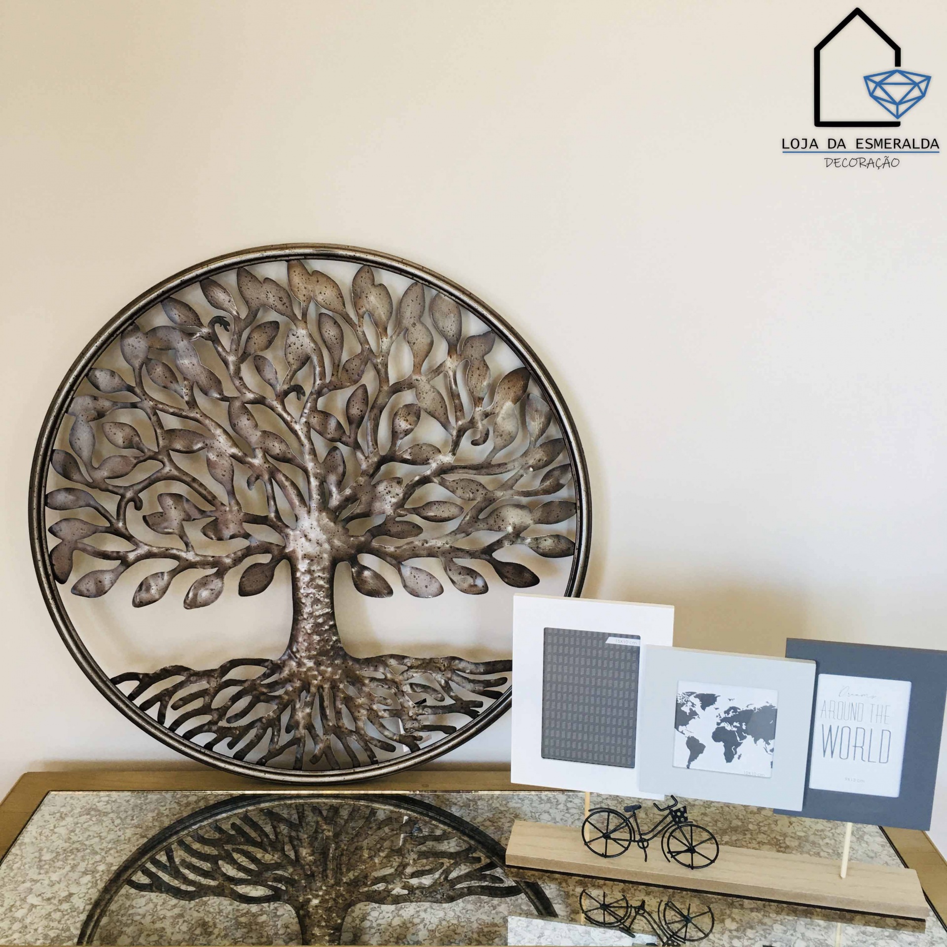 Decoração de parede com árvore da vida em metal e quadros decorativos sobre mesa espelhada