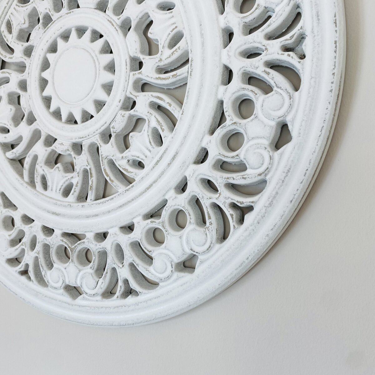 Painel decorativo redondo branco com padrão floral em relevo