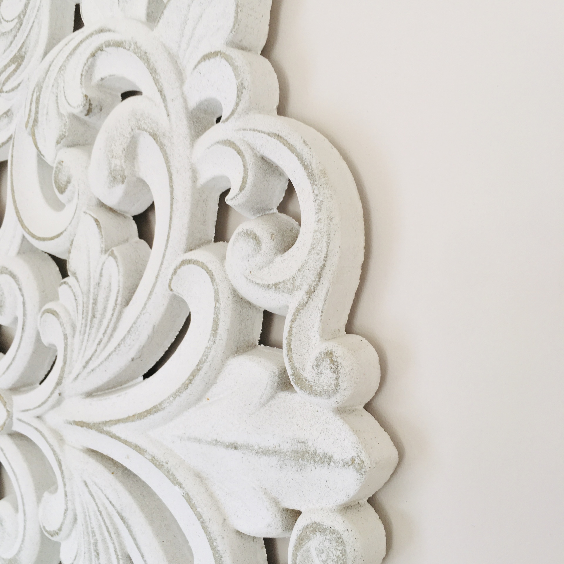 Peça decorativa de parede branca com padrão floral em relevo