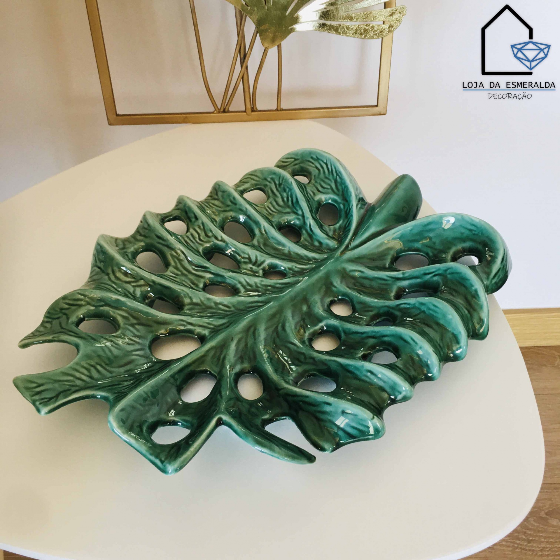 Prato decorativo cerâmico verde formato folha sobre mesa branca