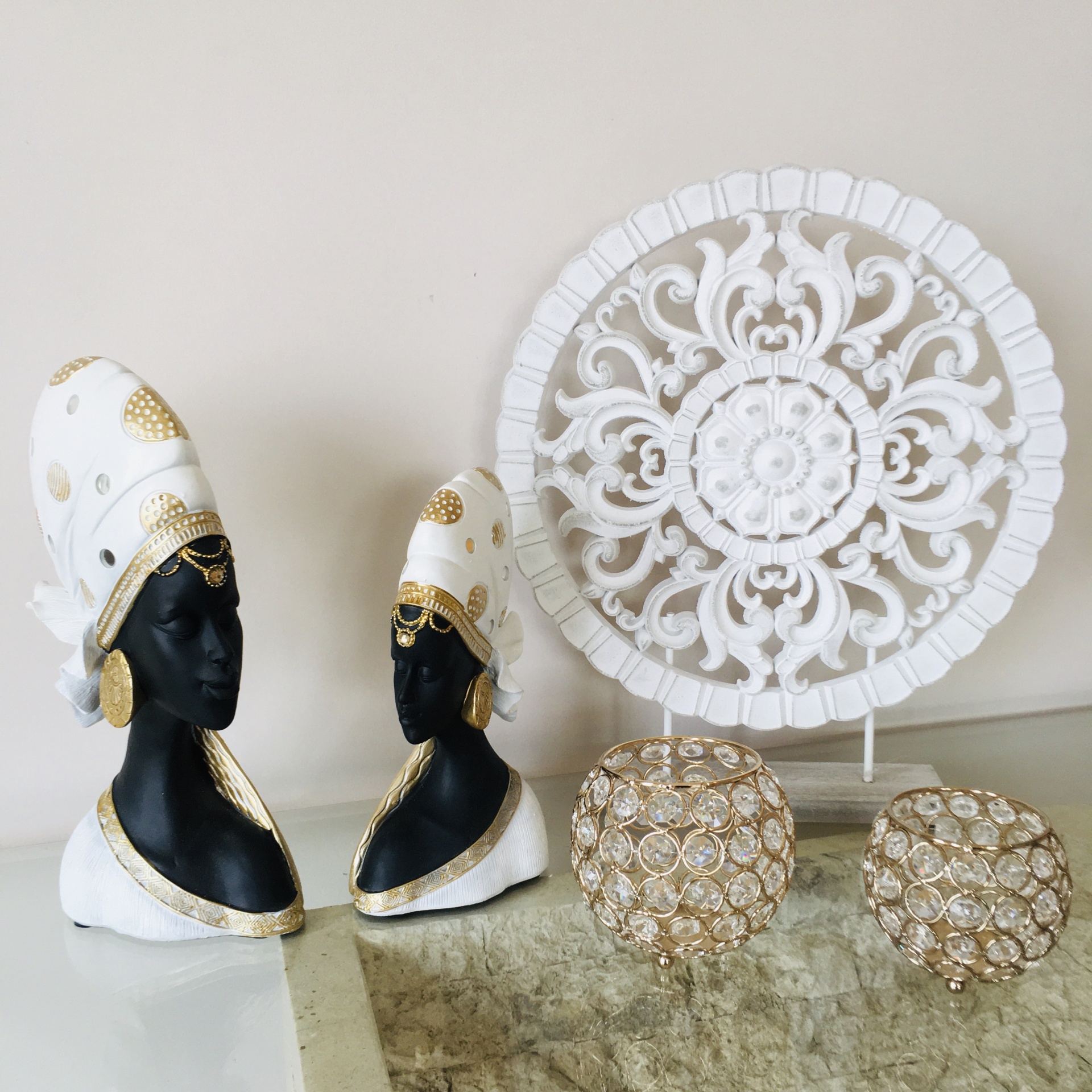 Bustos escultóricos femininos preto e branco com dourado e oratório branco floral com duas velas decorativas douradas