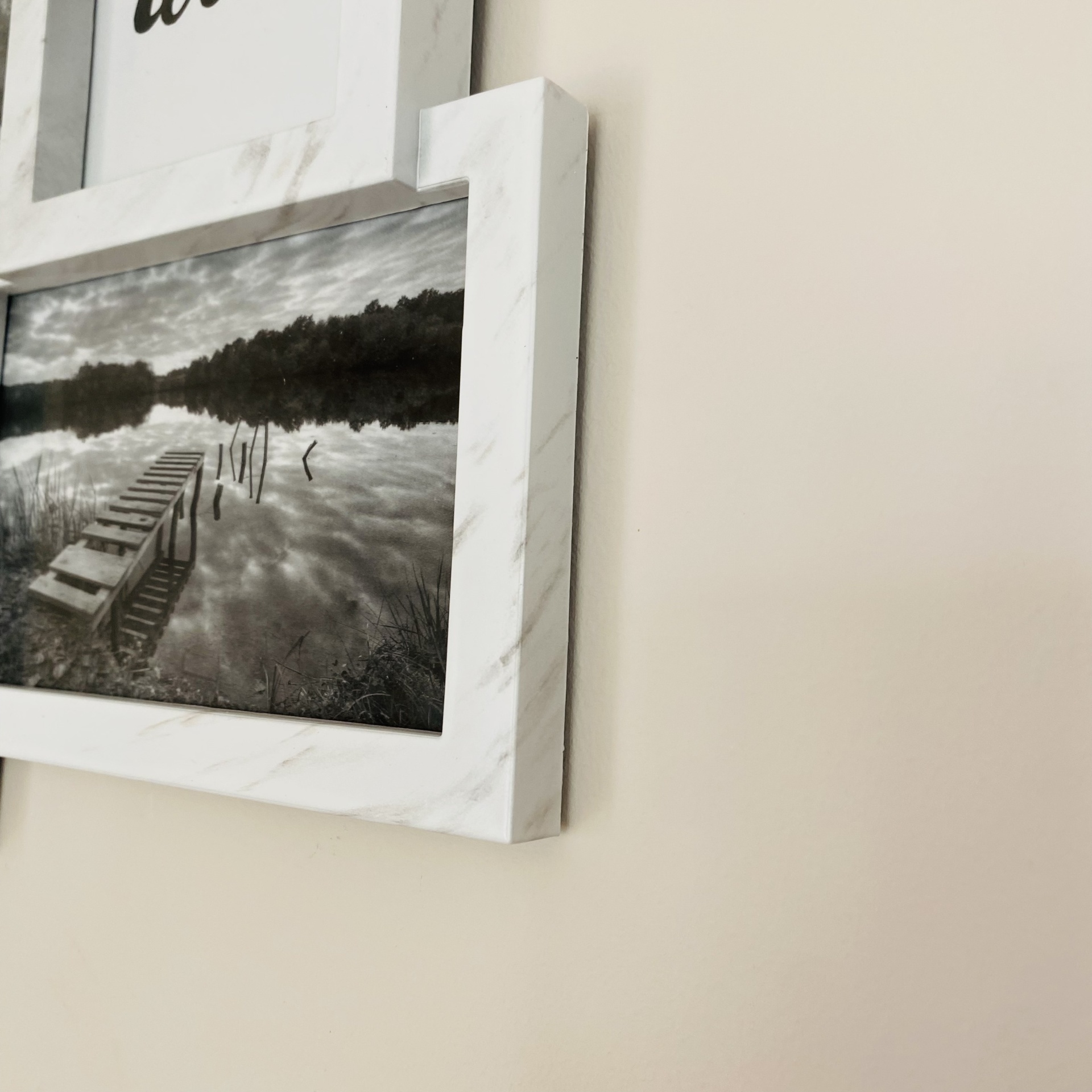 Moldura branca marmoreada com fotografia a preto e branco de cais sobre lago
