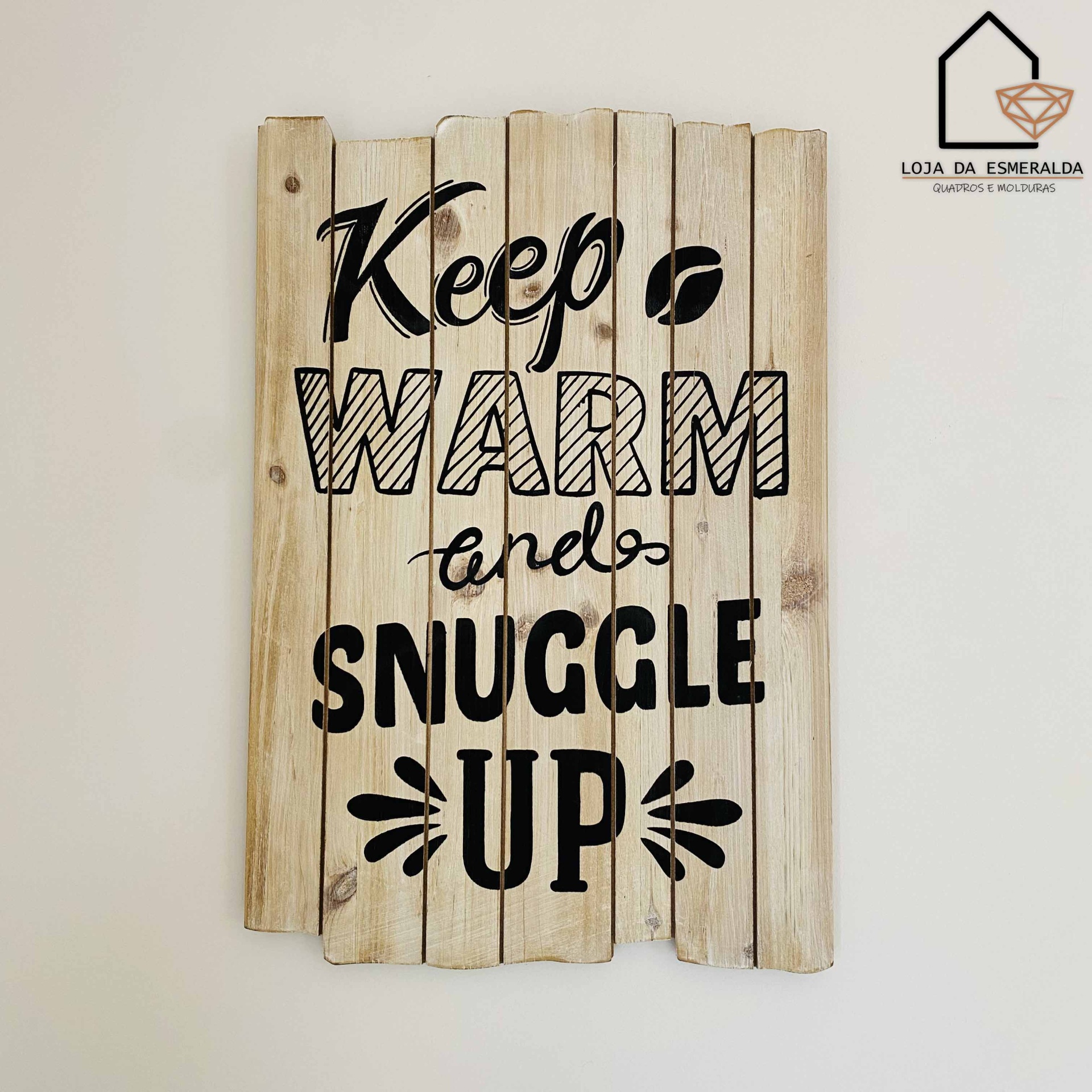 Placa decorativa de madeira com texto em preto pendurada na parede