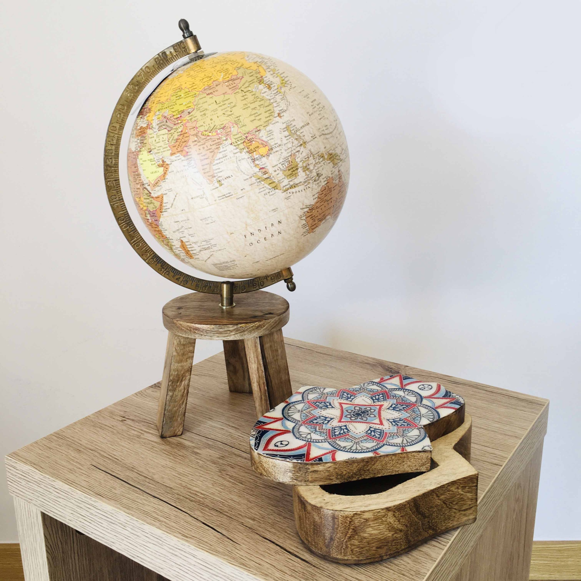 Globo terrestre decorativo com suporte de madeira e caixa decorativa em madeira sobre móvel
