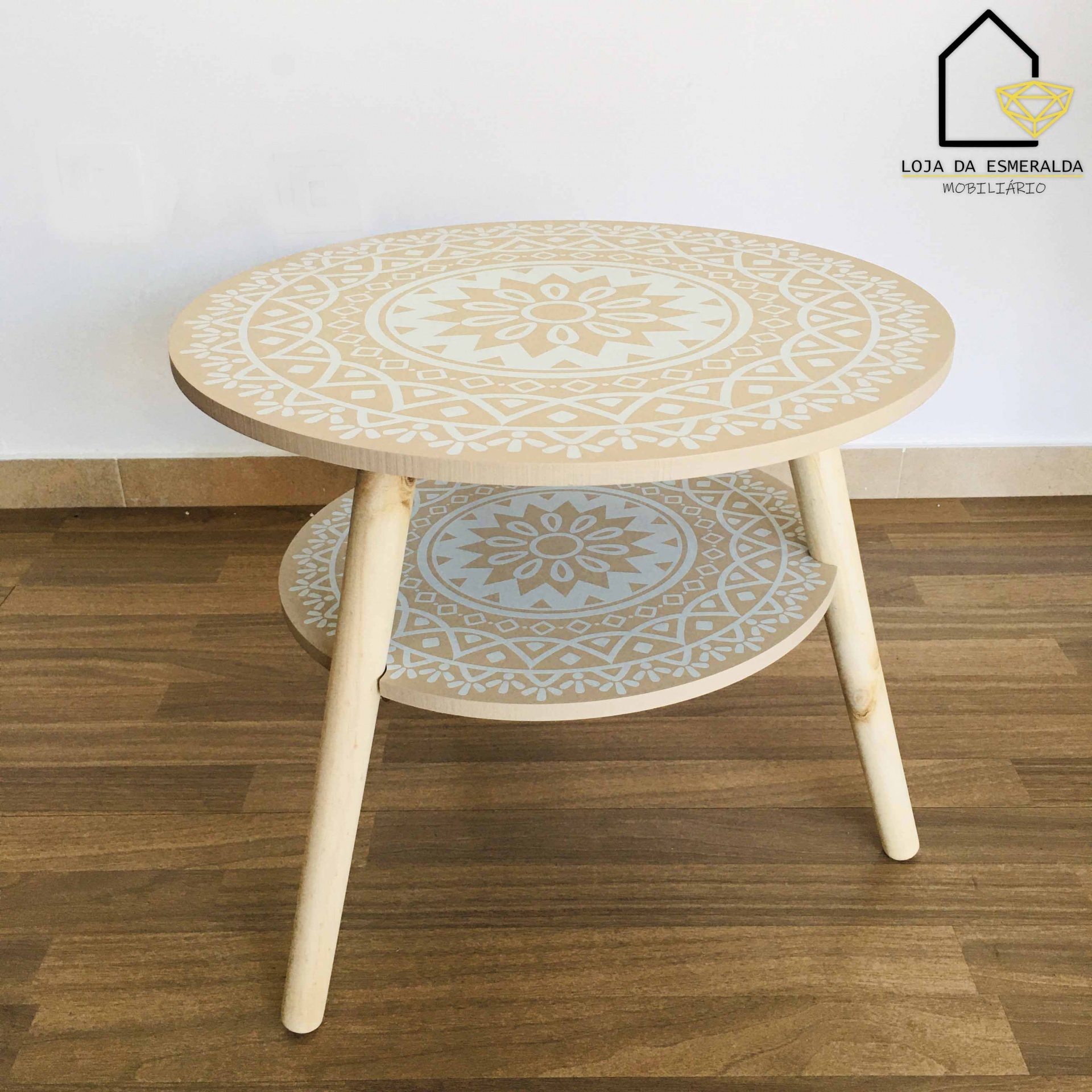Mesa de centro redonda em madeira clara com padrões florais geométricos brancos
