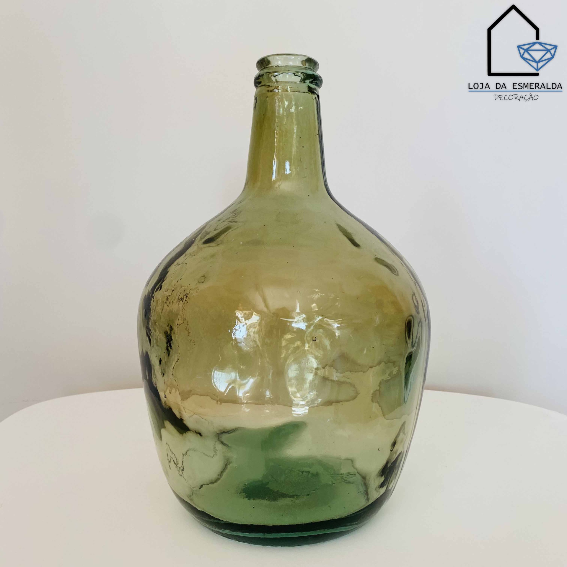 Garrafa decorativa em vidro verde claro com formato arredondado e pescoço estreito