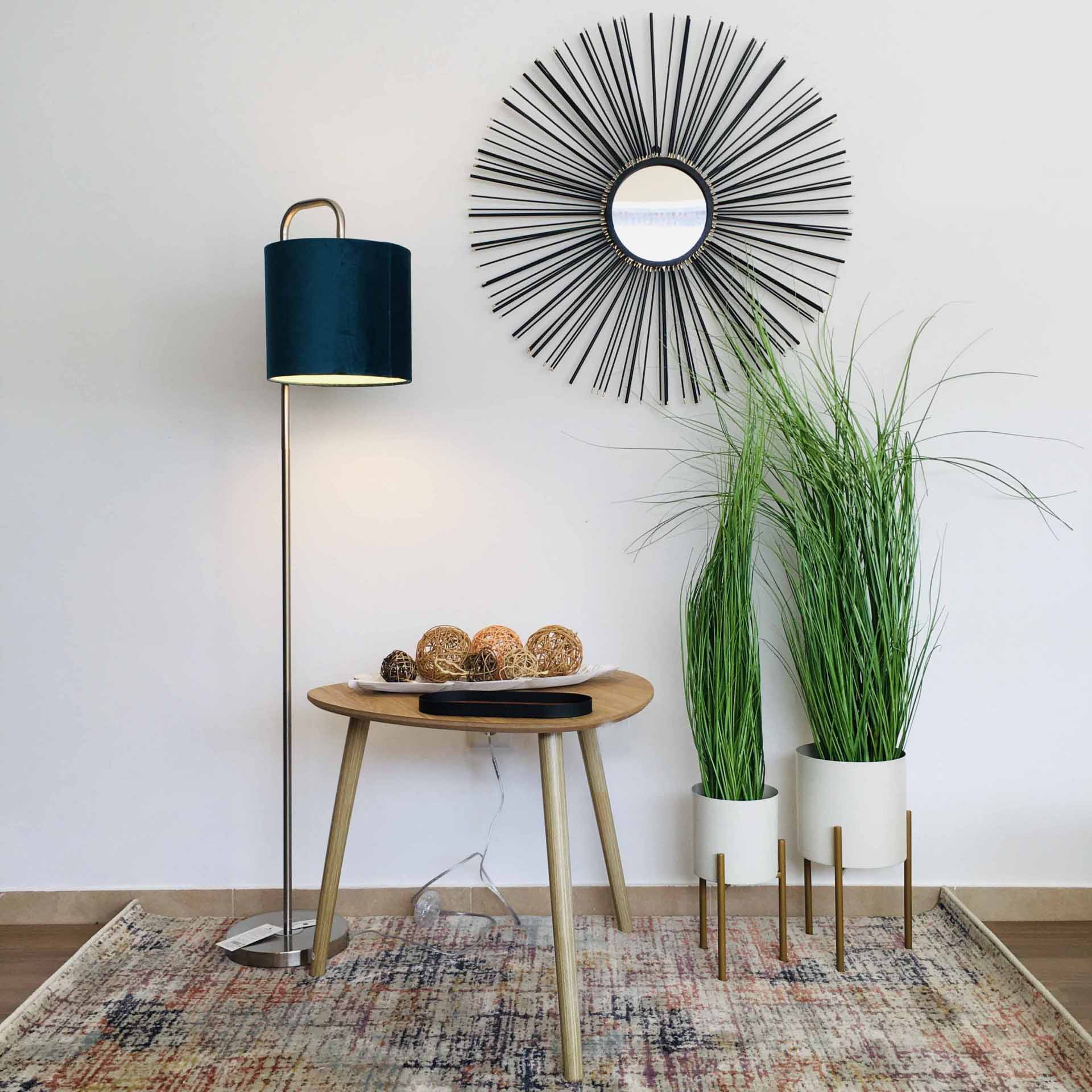 Abajur com cúpula azul, mesa madeira, espelho decorativo redondo preto, vasos brancos com plantas