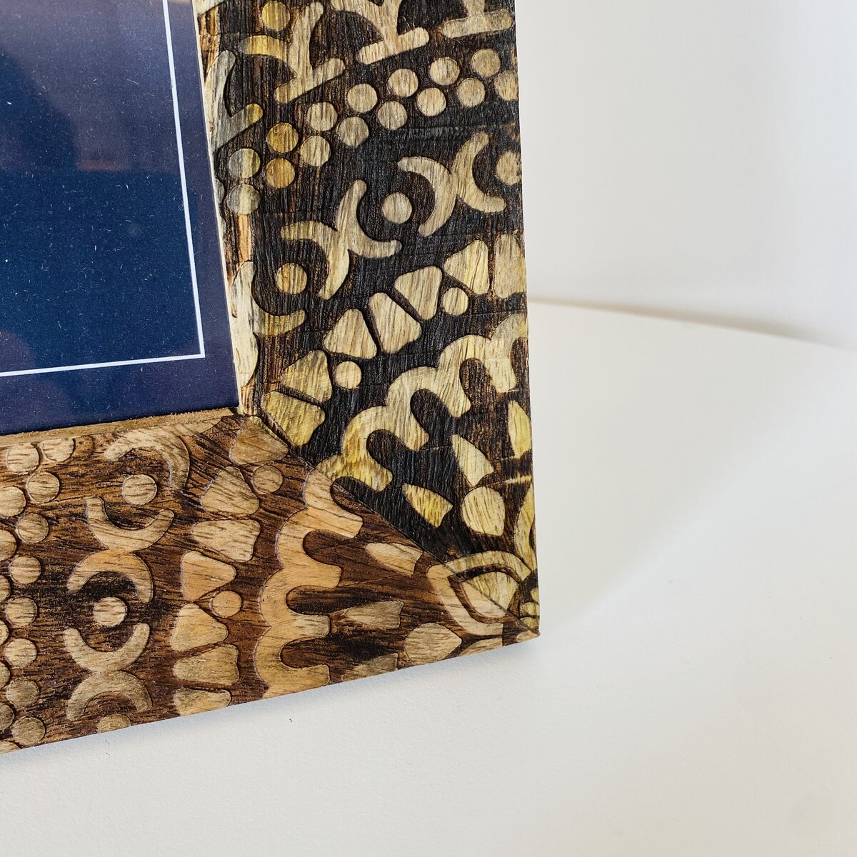 Detalhe de moldura de madeira decorativa com padrões entalhados