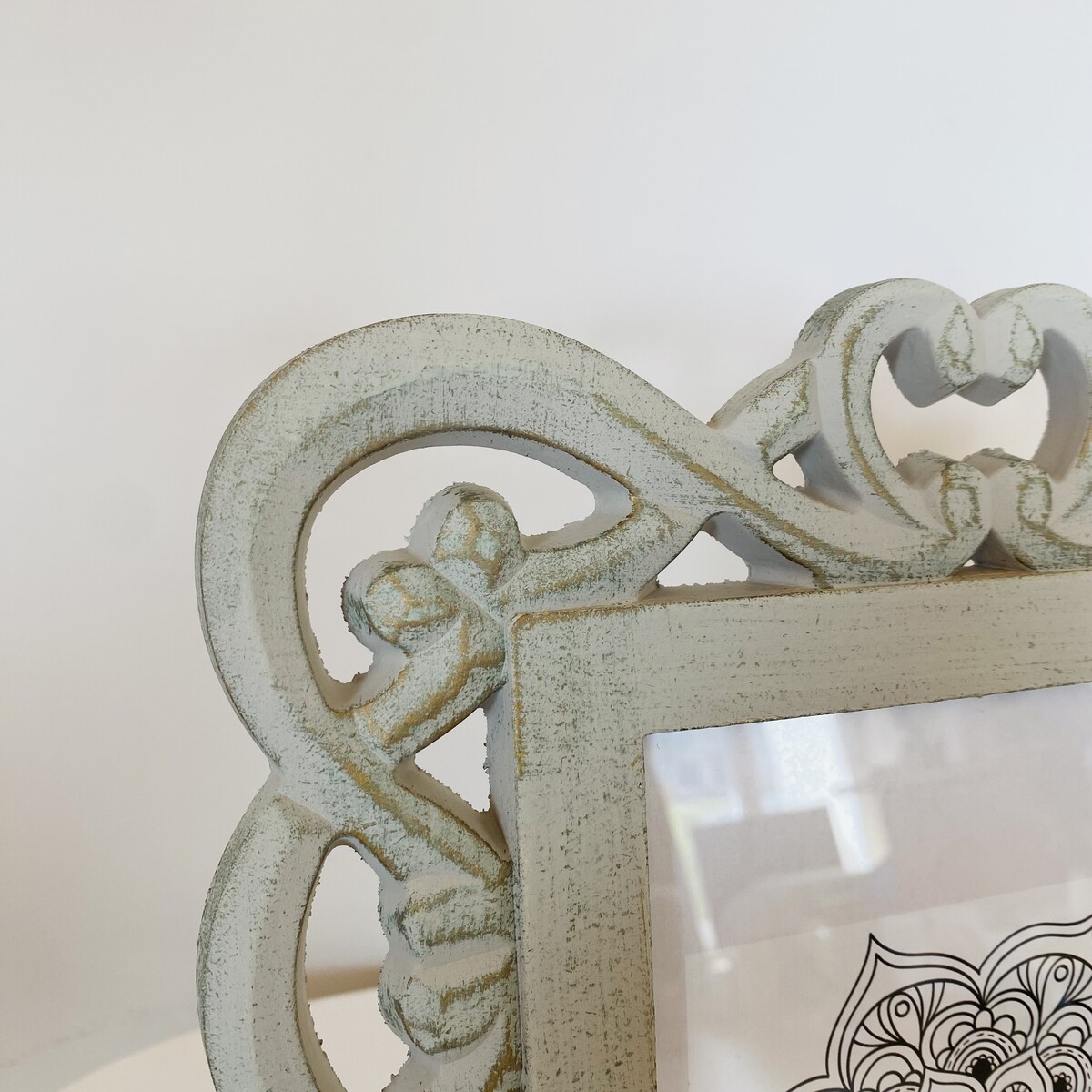 moldura de madeira branca envelhecida com entalhes florais e de coração