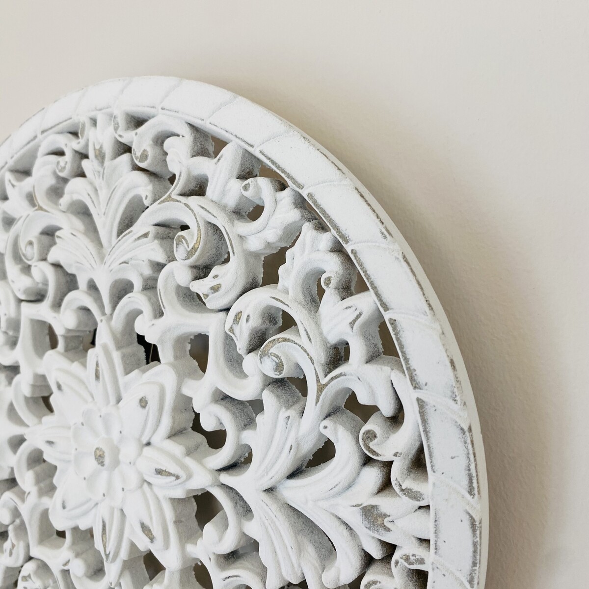Painel decorativo redondo branco com padrão floral em relevo na parede