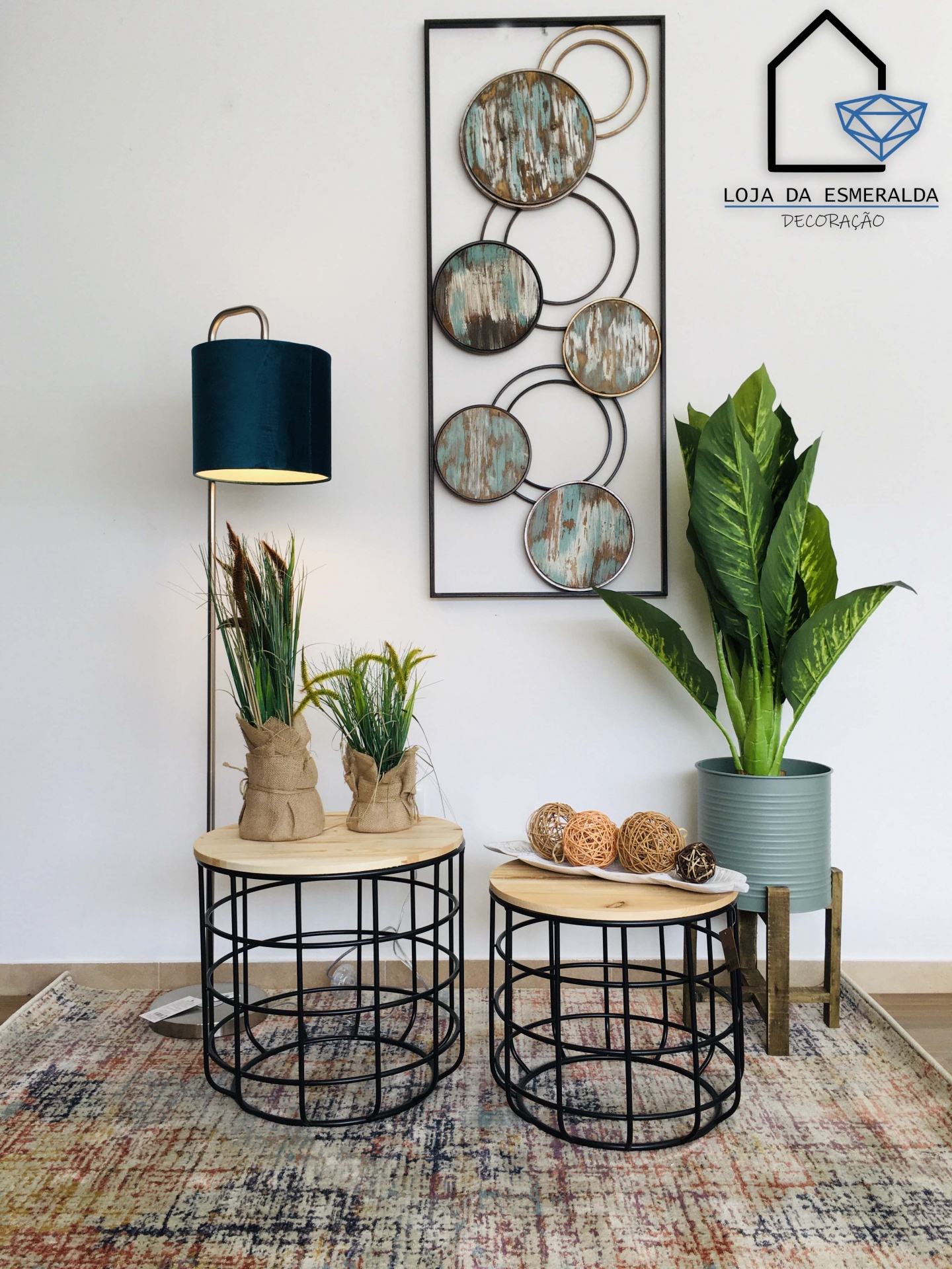 Conjunto de mesas de centro com decoração, luminária e quadro decorativo com círculos de madeira na parede branca