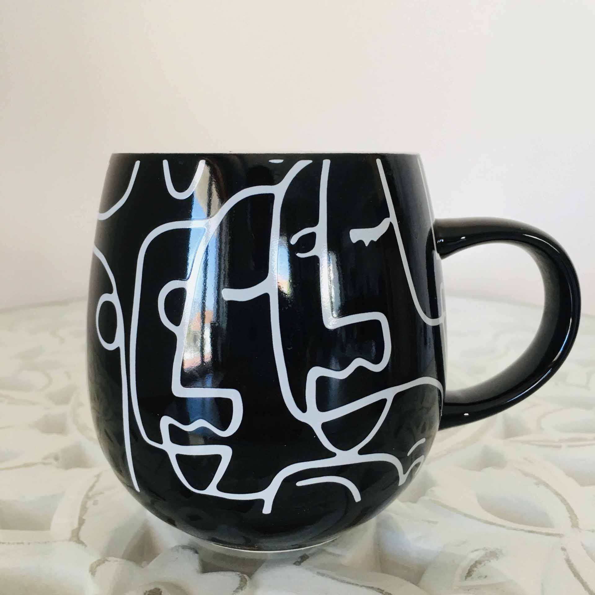 Caneca preta com padrão branco de rostos abstratos