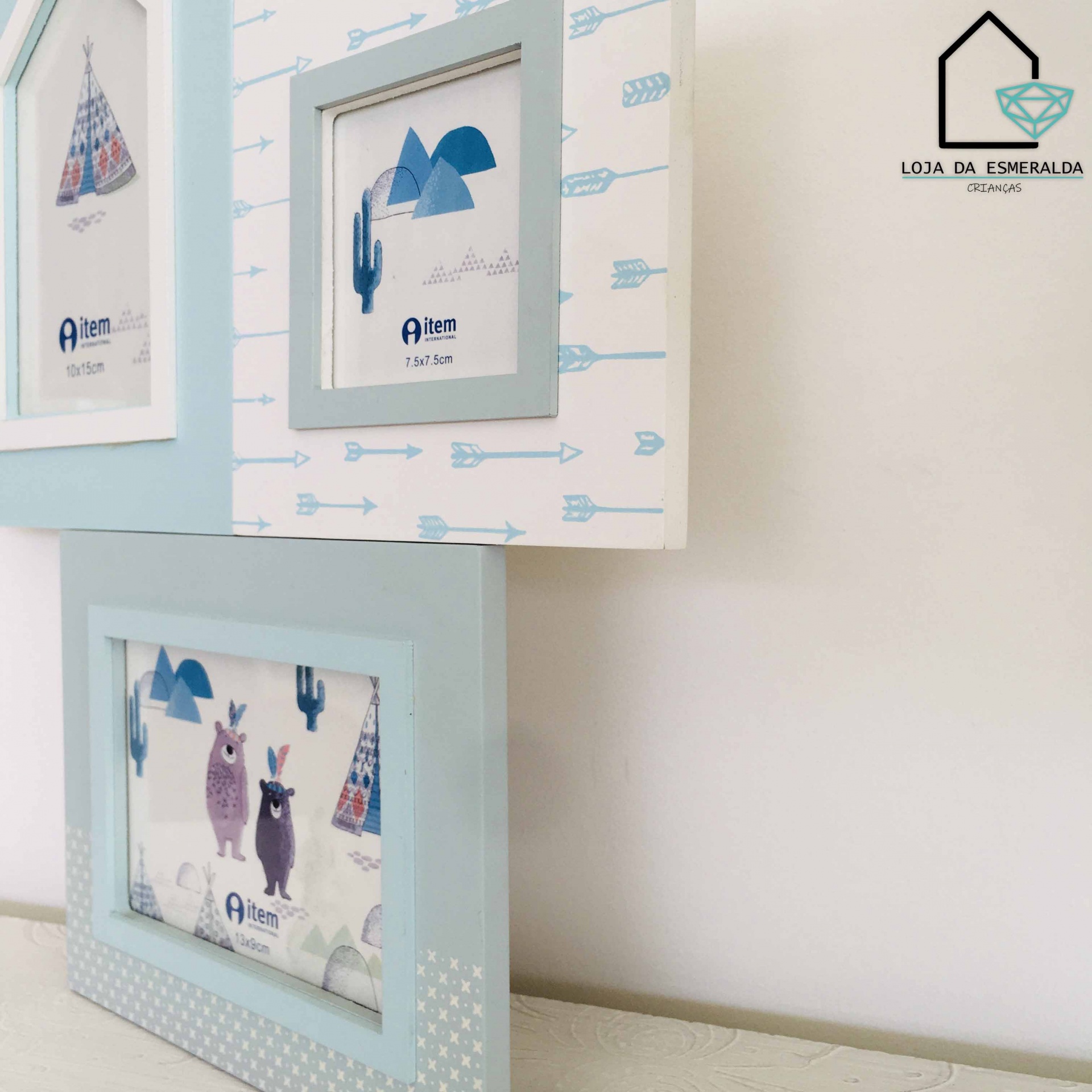 Três molduras decorativas infantis com ilustrações em tons azuis e brancos, penduradas numa parede clara.