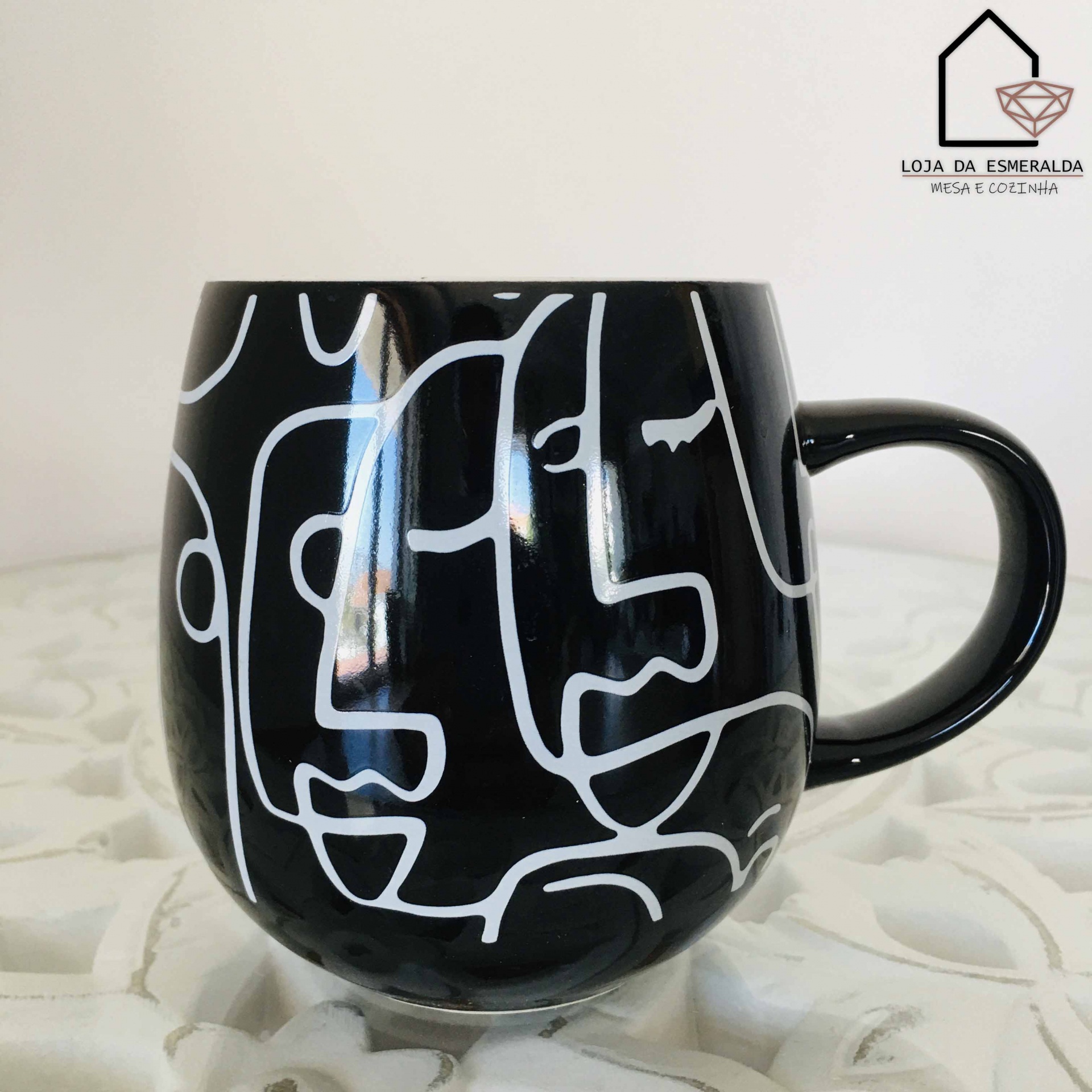 Caneca preta com padrão branco abstrato e pega arredondada