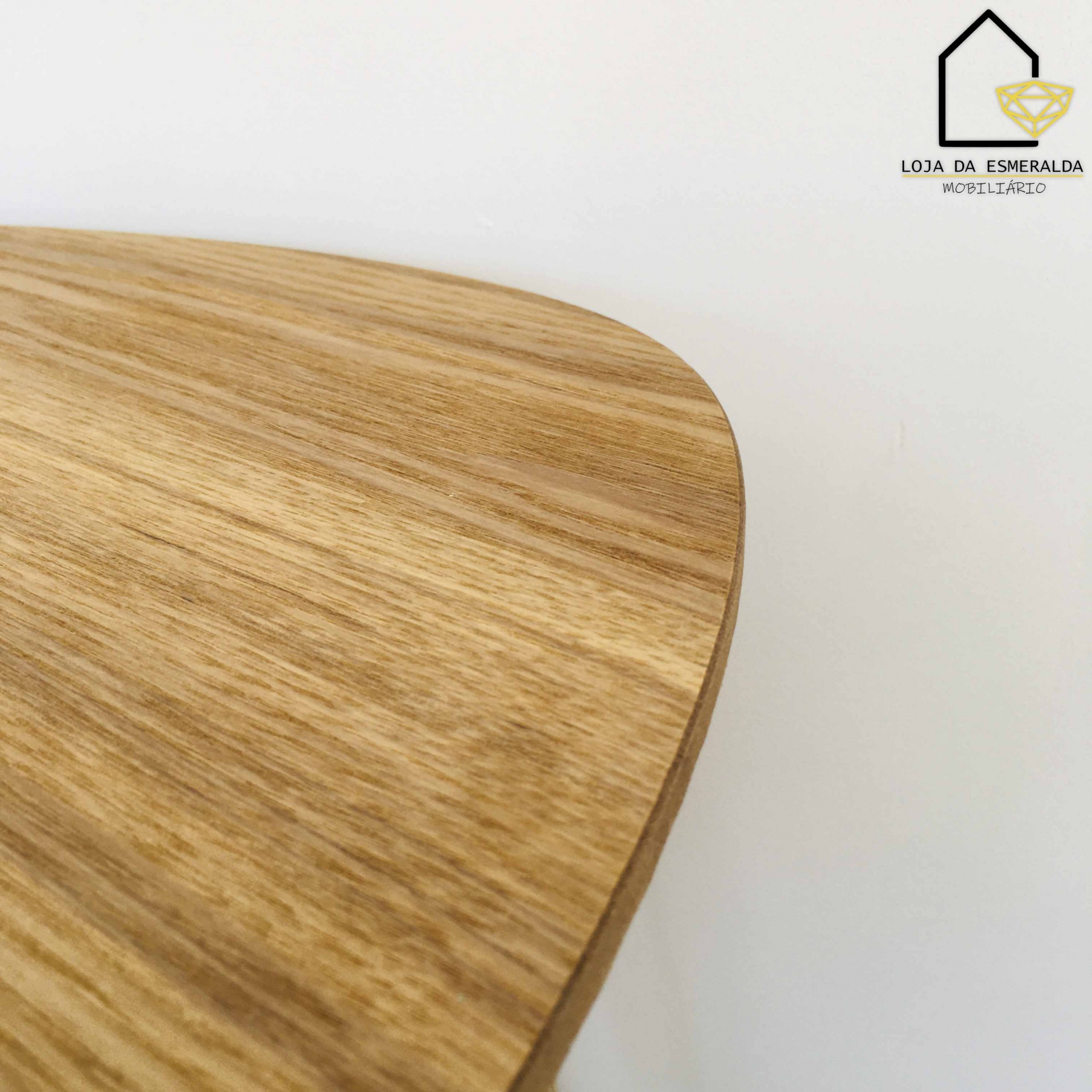Mesa de madeira clara com logótipo LOJA DA ESMERALDA MOBILIÁRIO no canto