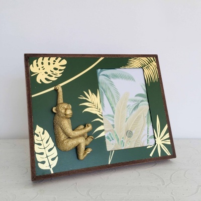 Porta-retrato verde com folhas douradas e figura de macaco dourado em madeira