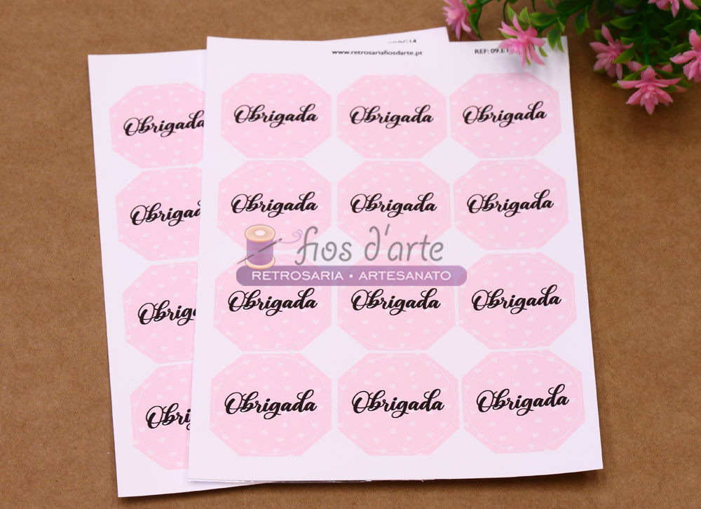 Folhas com etiquetas autocolantes cor-de-rosa claro com a palavra Obrigada