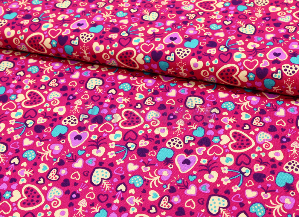 Tecido rosa com padrão colorido de corações em vários tamanhos