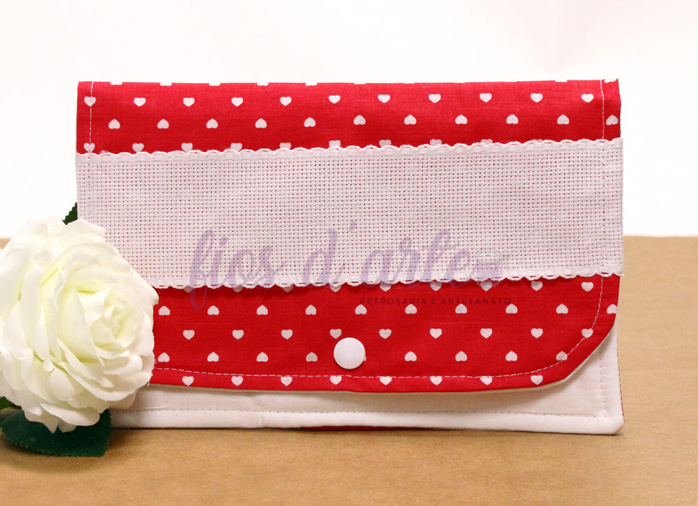 Carteira vermelha com corações brancos e faixa branca com texto 'lios d'arte'