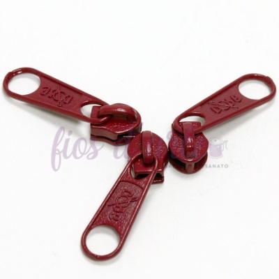 Fechos éclair metálicos vermelhos com texto YKK em fundo branco