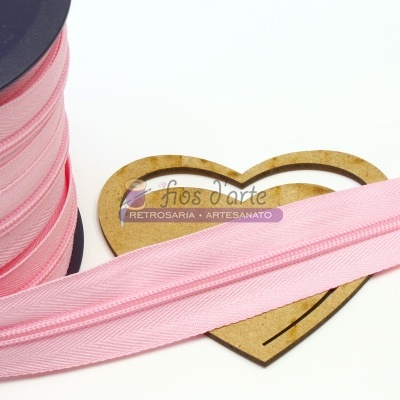 Rolo de fita cor-de-rosa claro com suporte em forma de coração de madeira