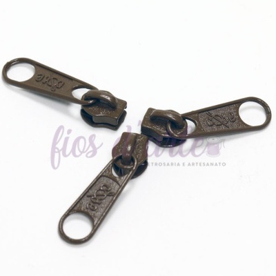 Três puxadores de zipper metálicos bronze com números e palavras gravadas