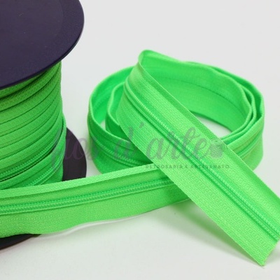 Fecho éclair verde fluorescente em rolo e solto em tecido sintético