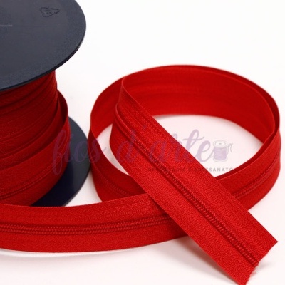 Fita com fecho de correr vermelho em carretel sobre fundo branco