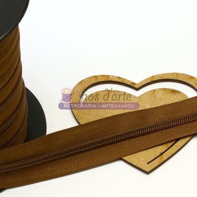 Bobina de fita marrom em tecido com recorte de madeira em forma de coração