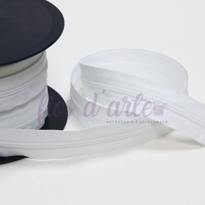 Rolo de fecho éclair branco enrolado numa bobina preta