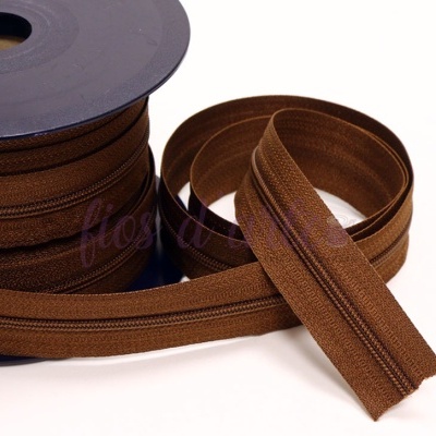Fita de fecho éclair castanha enrolada em carretel preto com extremidade solta
