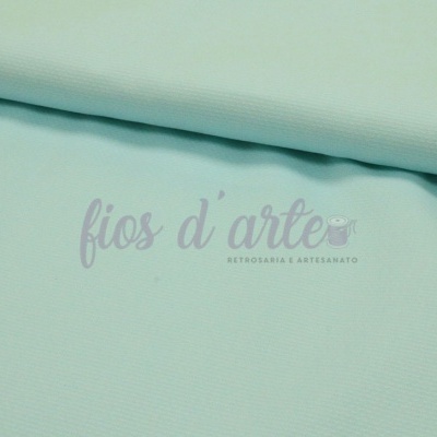 Tecido azul claro com textura fina e marca dágua sobre superfície branca