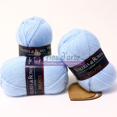 Três novelos de lã azul claro VALERIA di ROMA DELFOS sobre fundo branco