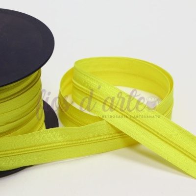 Rolo de fecho éclair amarelo em bobina preta sobre fundo branco