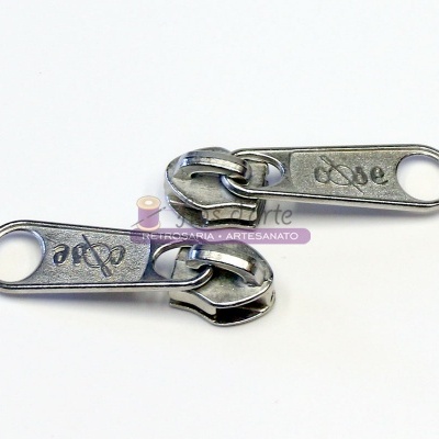 Dois puxadores de fecho éclair metálicos prateados com símbolos gravados