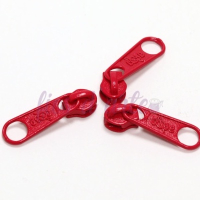 Três puxadores de fecho éclair vermelhos em fundo branco